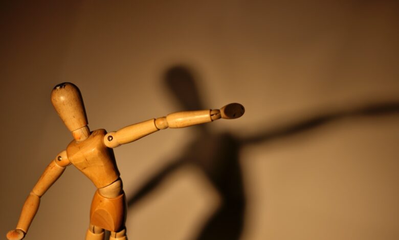a wooden toy with a long shadow on a wall