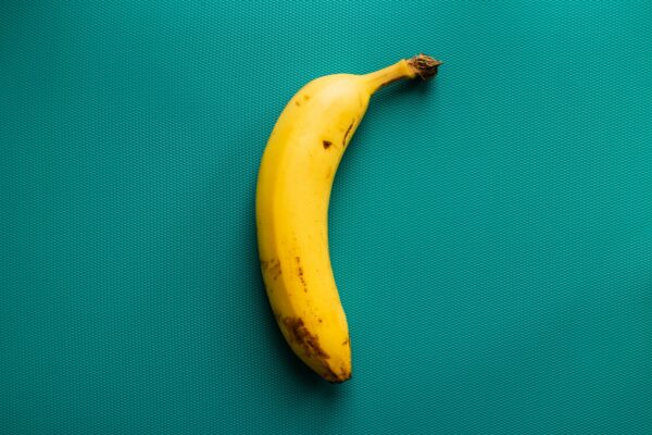 a ripe banana sitting on top of a green surface