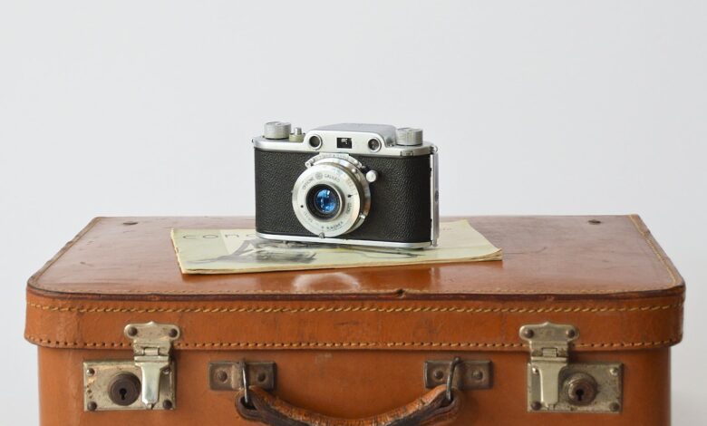 a camera sitting on top of a brown suitcase