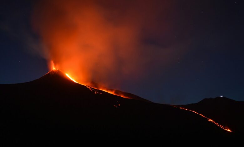 black mountain with flowing lava at nighttime