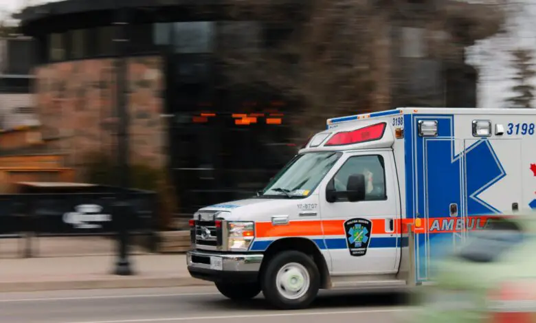 white and blue ambulance van traveling on road