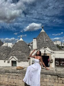 Woman Posing on Wall by Trulli Houses in Alberobello