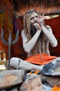 A man with dreadlocks sitting on a rock