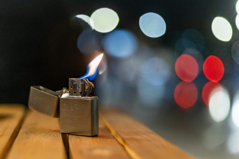 Accendino acceso con fiamma su un tavolo di legno