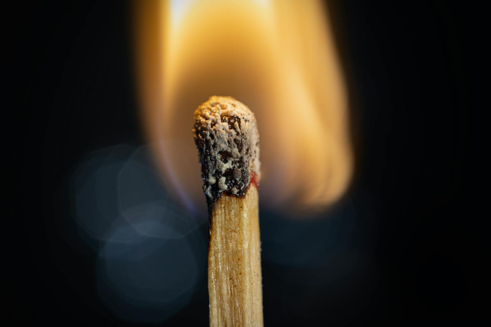 Fiammifero di legno acceso con fiamma vivace in primo piano