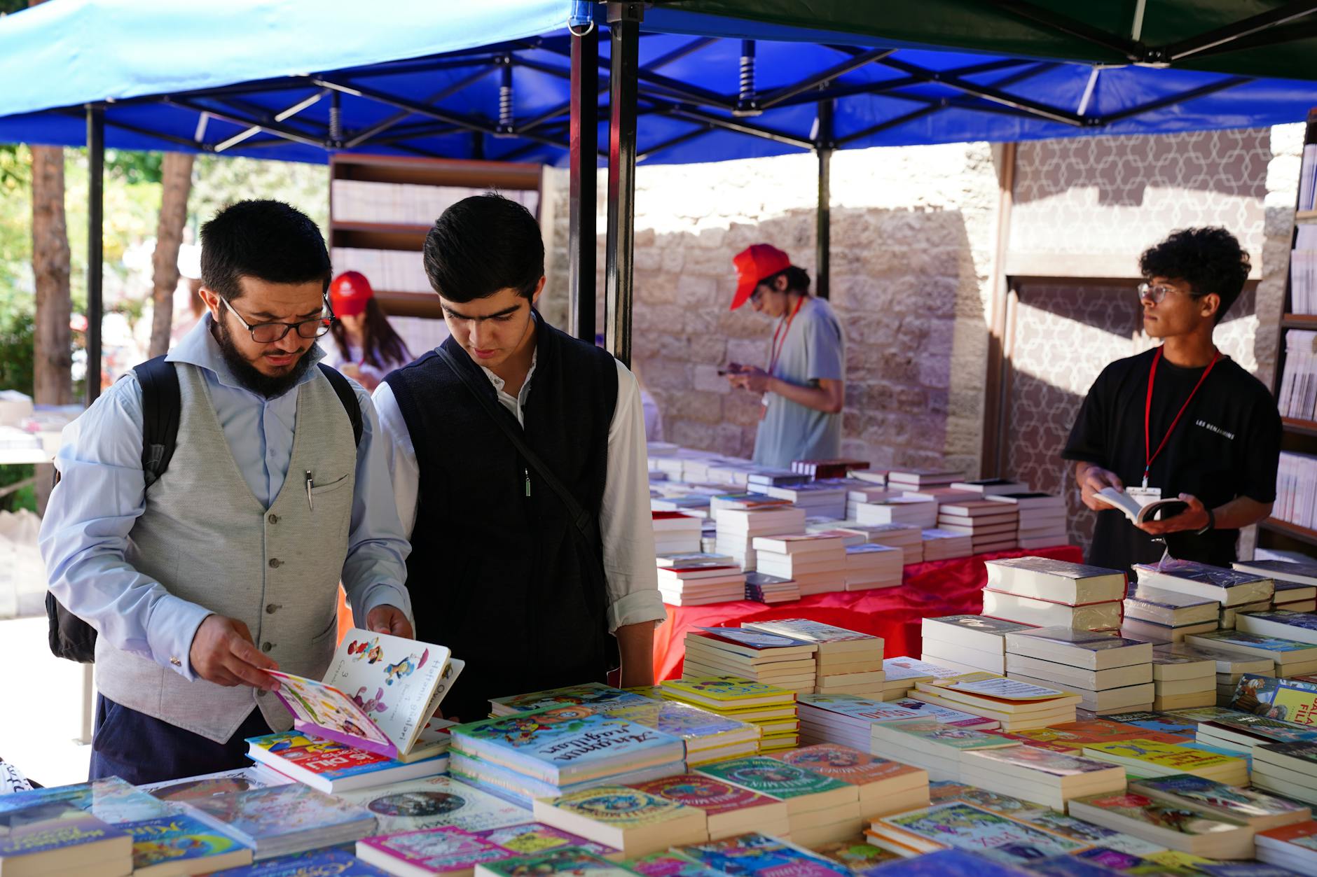 Lettori che sfogliano libri all'aperto in un giardino