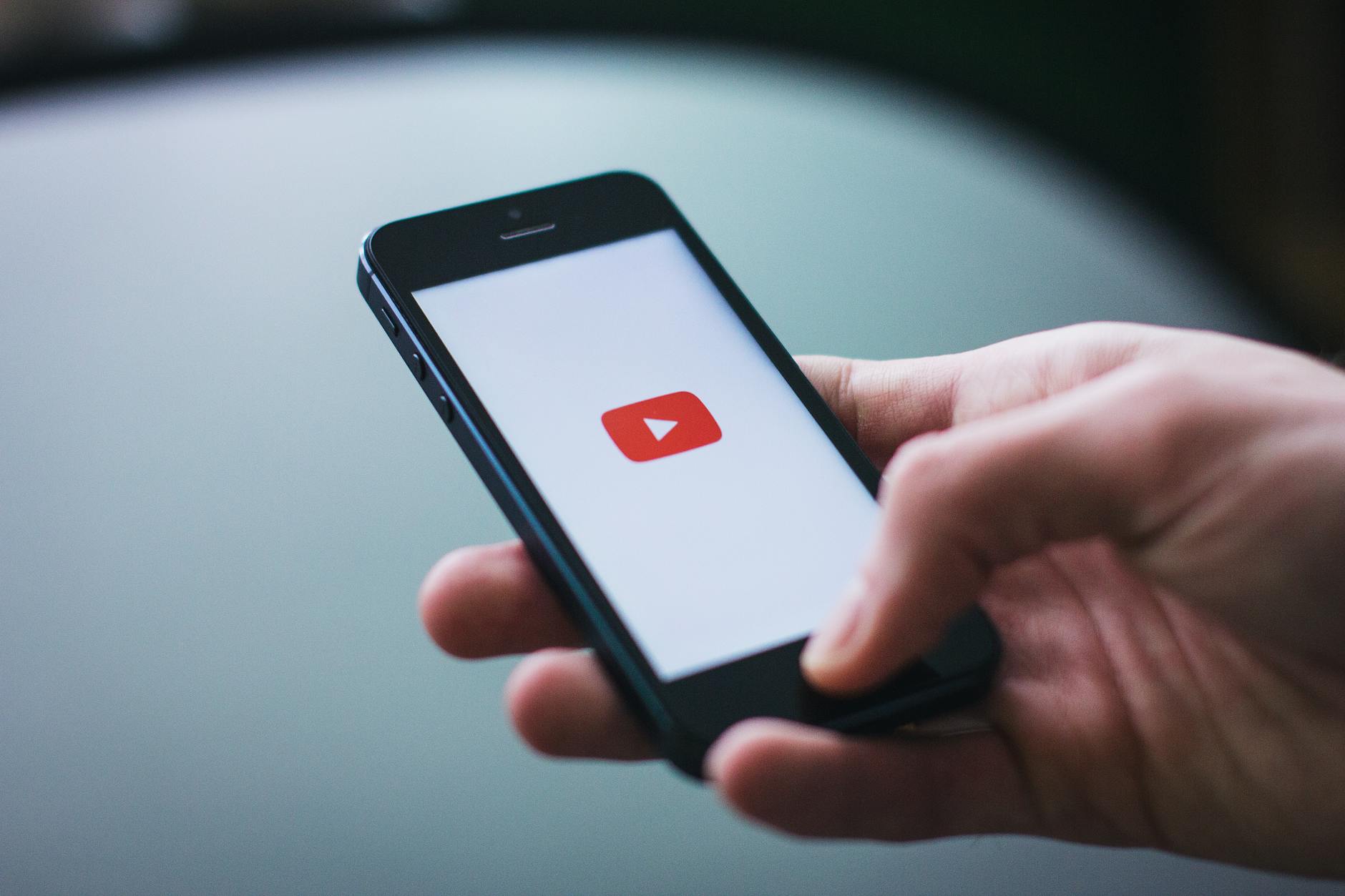 Schermata di YouTube su uno smartphone tra le mani