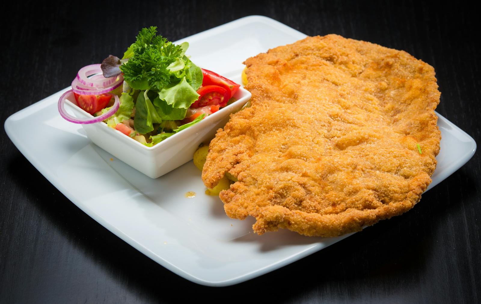 Cotoletta dorata e croccante servita con insalata fresca