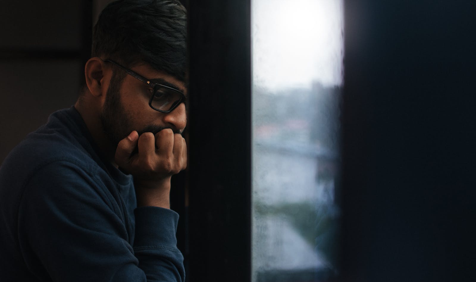 Uomo che guarda fuori dalla finestra, immagine simbolo del déjà-vu