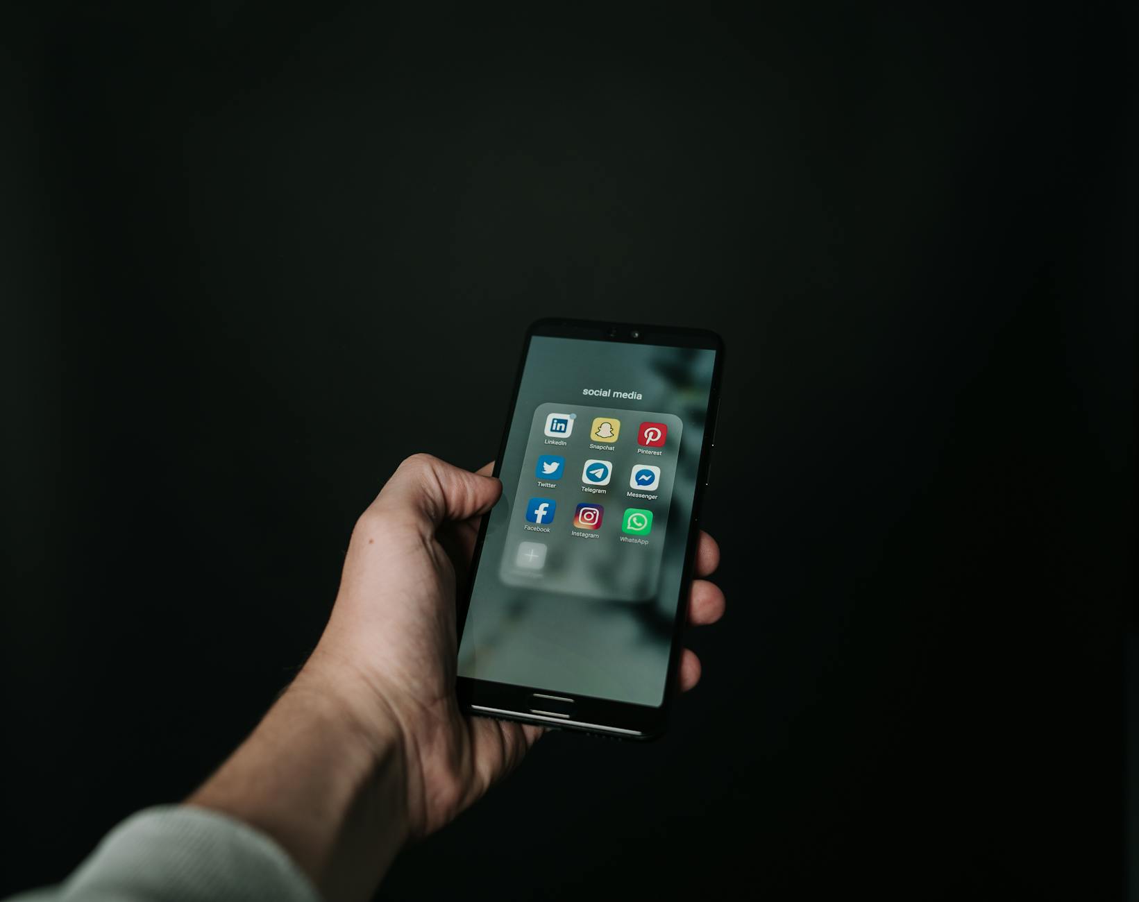 Mano che tiene uno smartphone con notifiche social