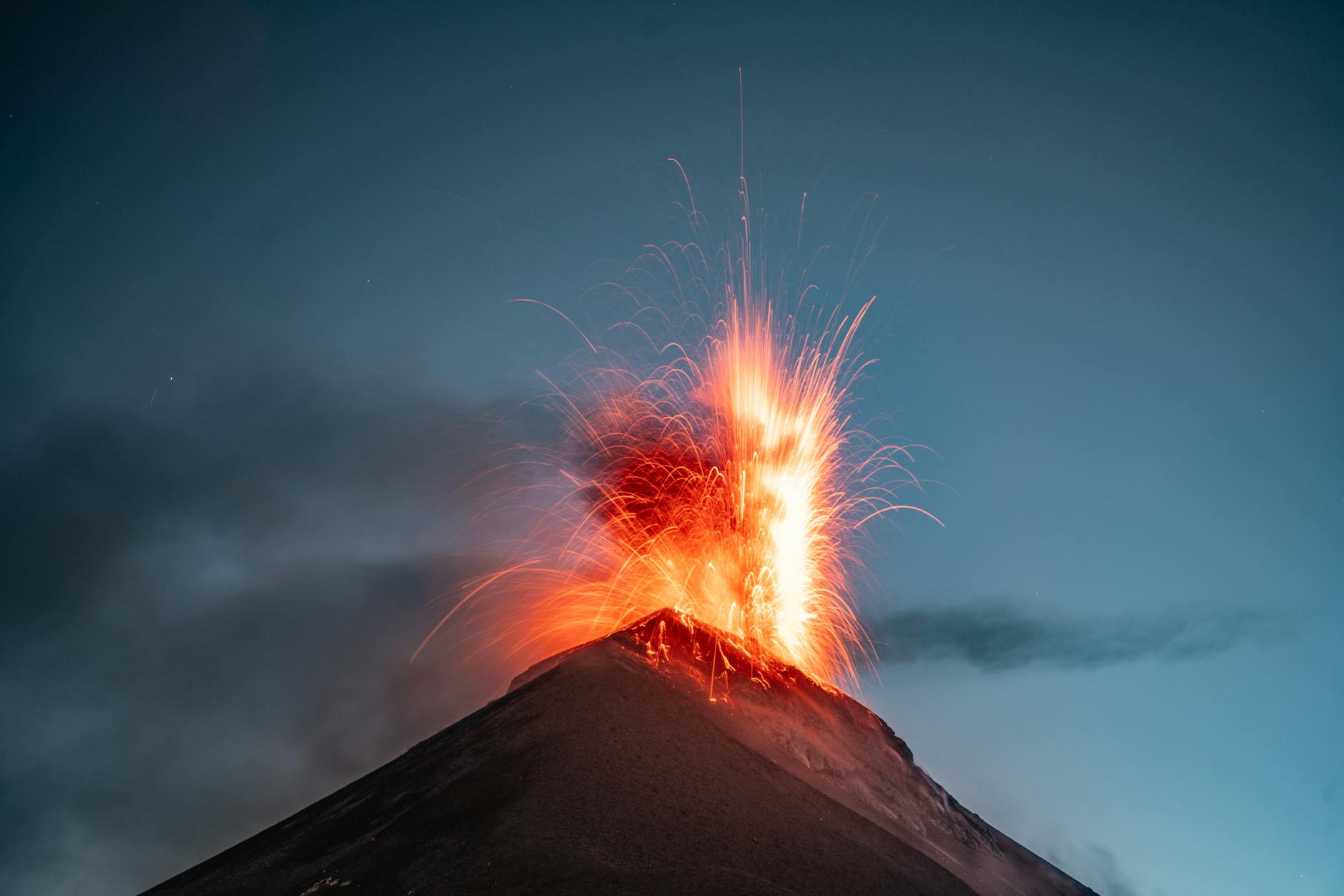 Vulcano in eruzione con colonna di fumo