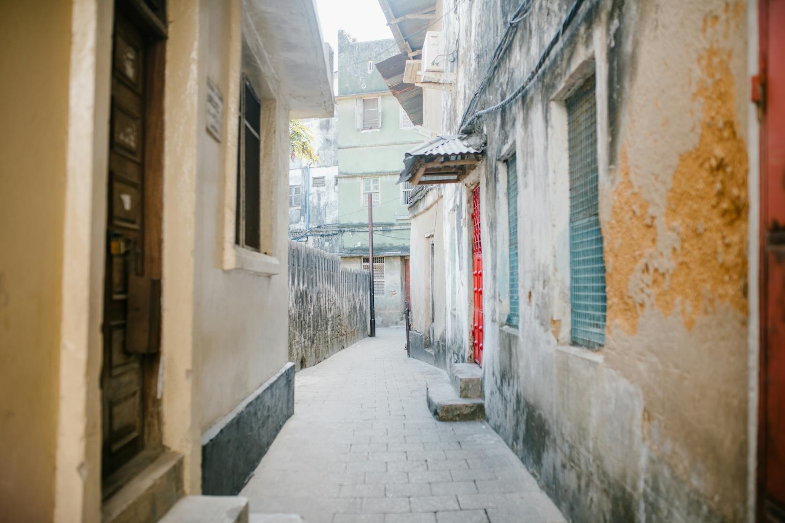 Stretta via lastricata tra antiche case in pietra a Stone Town