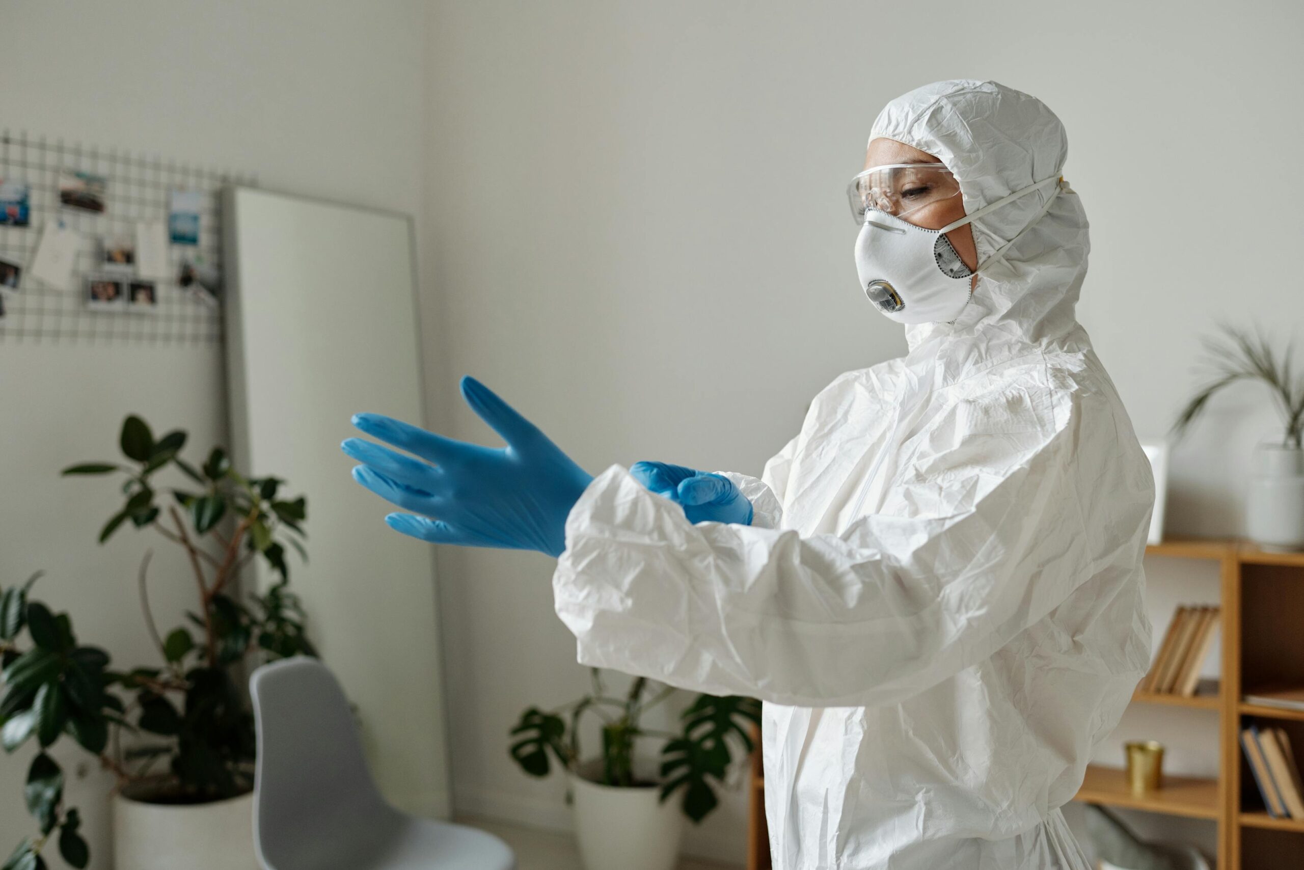 Operatore con dispositivi di protezione individuale per pulizia ambienti contaminati