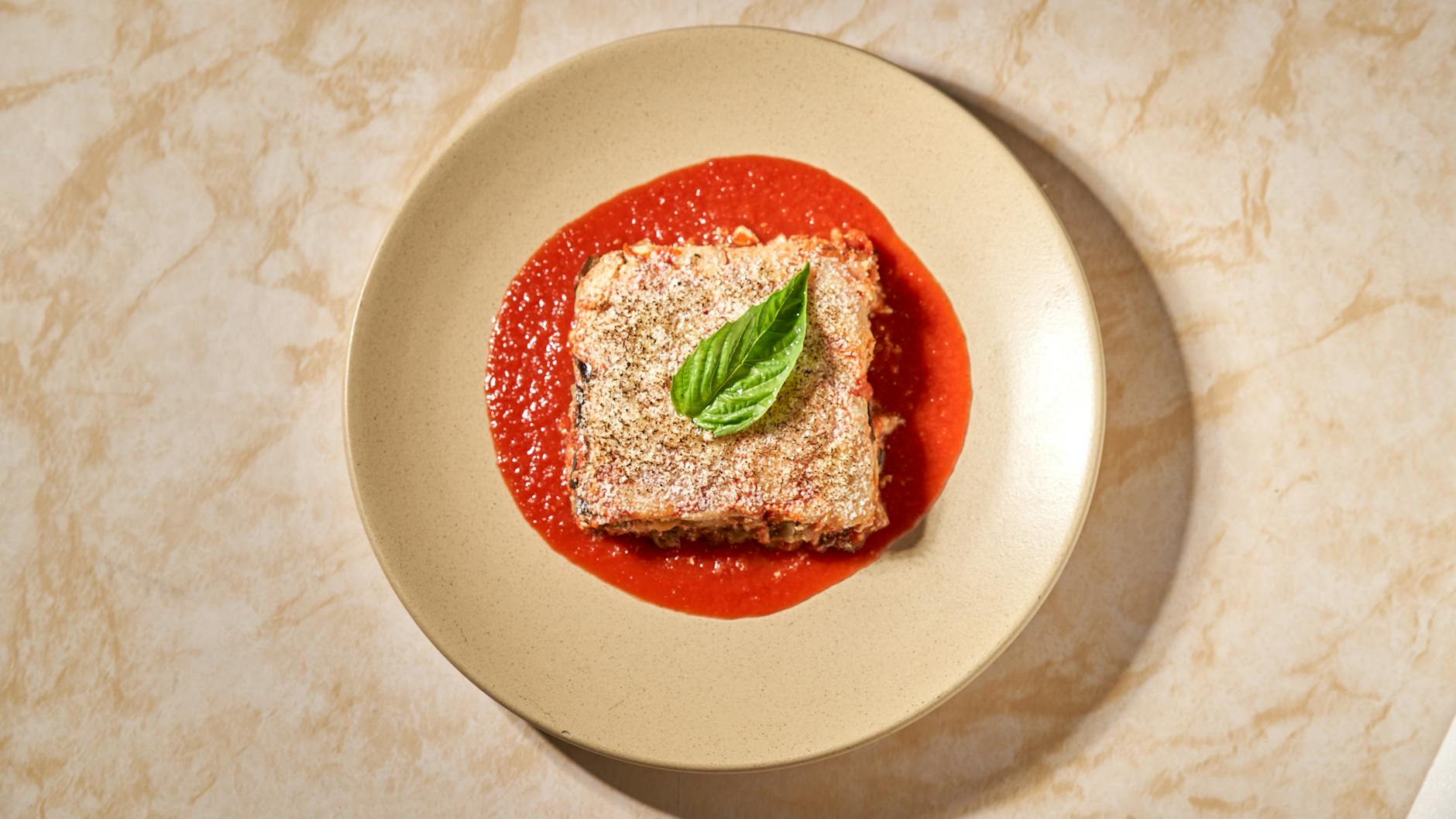 Strati di melanzane, sugo di pomodoro e formaggio in preparazione