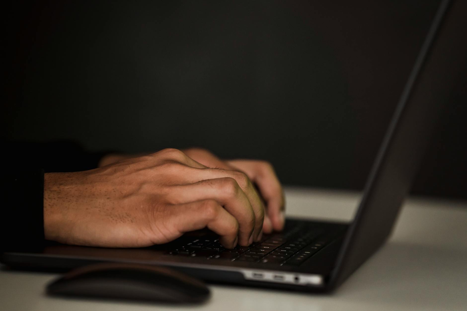 Ritaglia La Persona Senza Volto Usando Il Laptop Nell'oscurità
