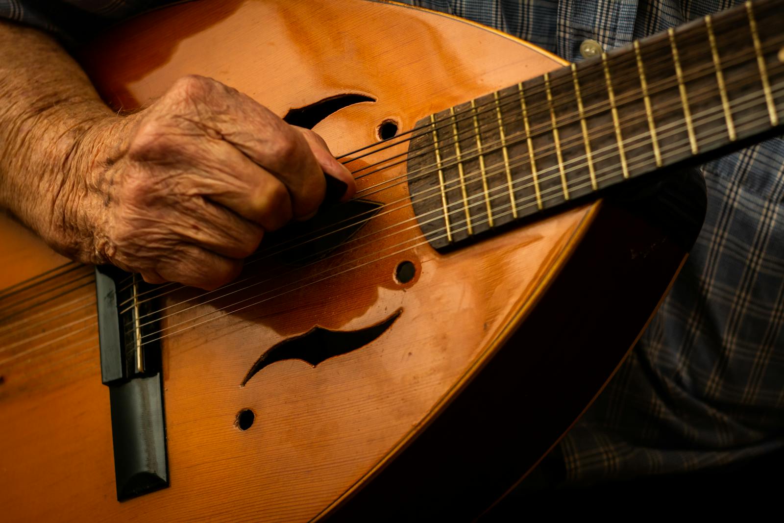 Mani che suonano una chitarra portoghese, strumento del fado e della saudade