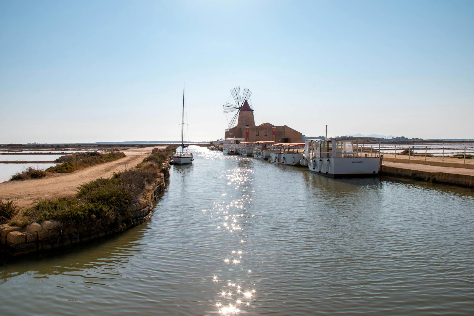 Mulino a vento e canale del territorio di Marsala con barche