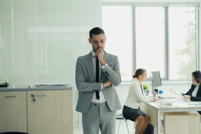 Uomo riflessivo in ufficio simbolo della sindrome dell'impostore