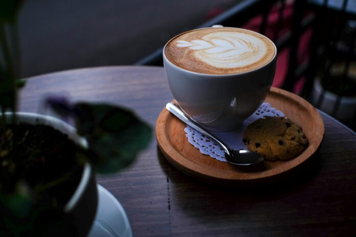 Cappuccino con latte art classico in tazza bianca