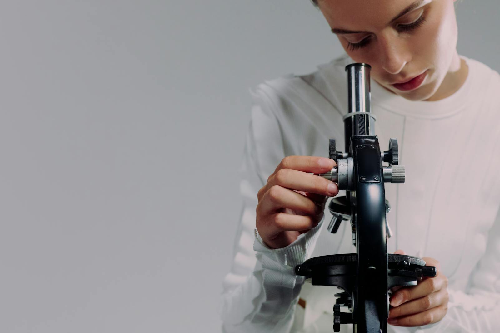 Scienziato che esamina campioni al microscopio