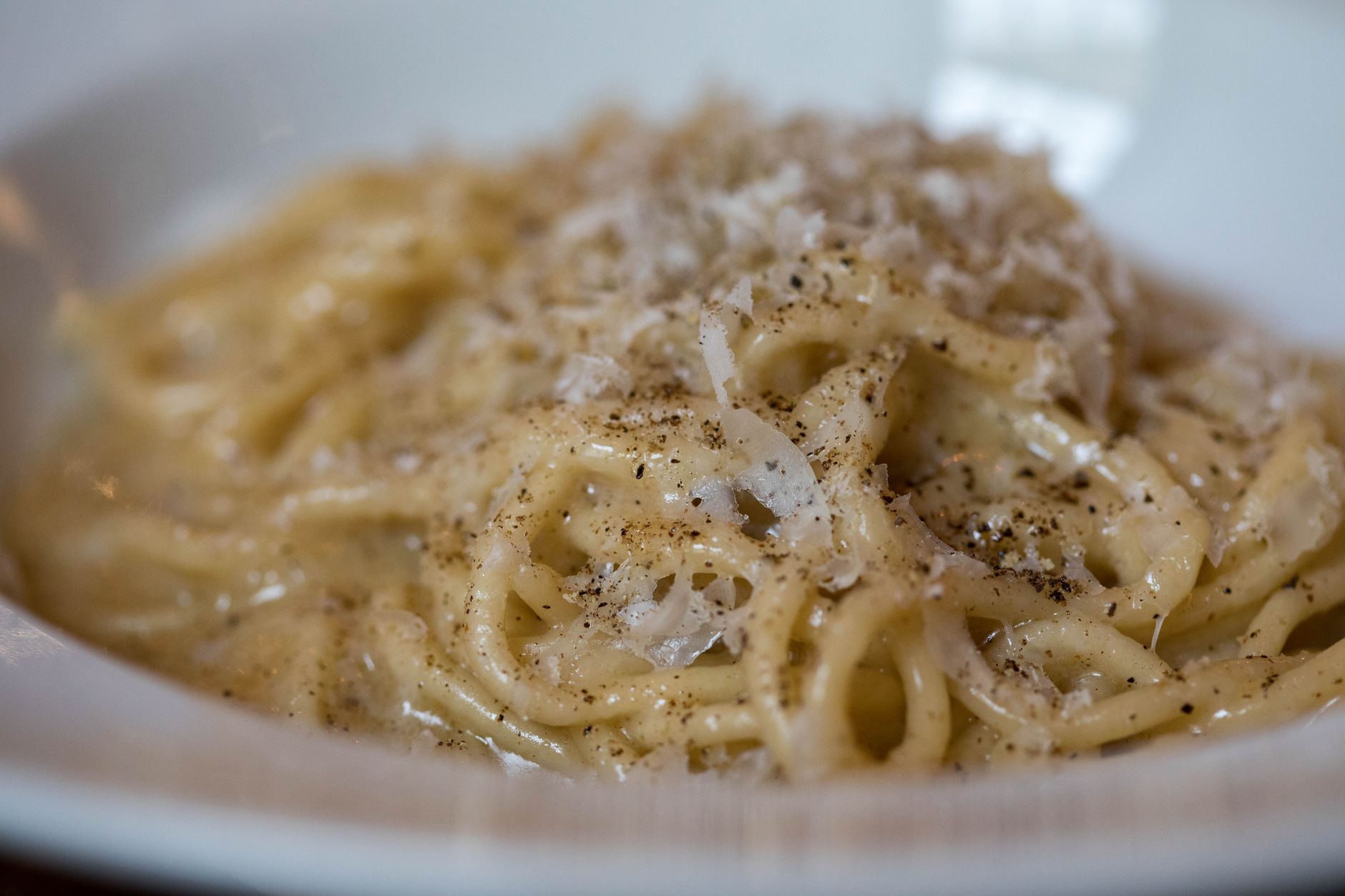Pecorino romano grattugiato accanto a pasta fresca