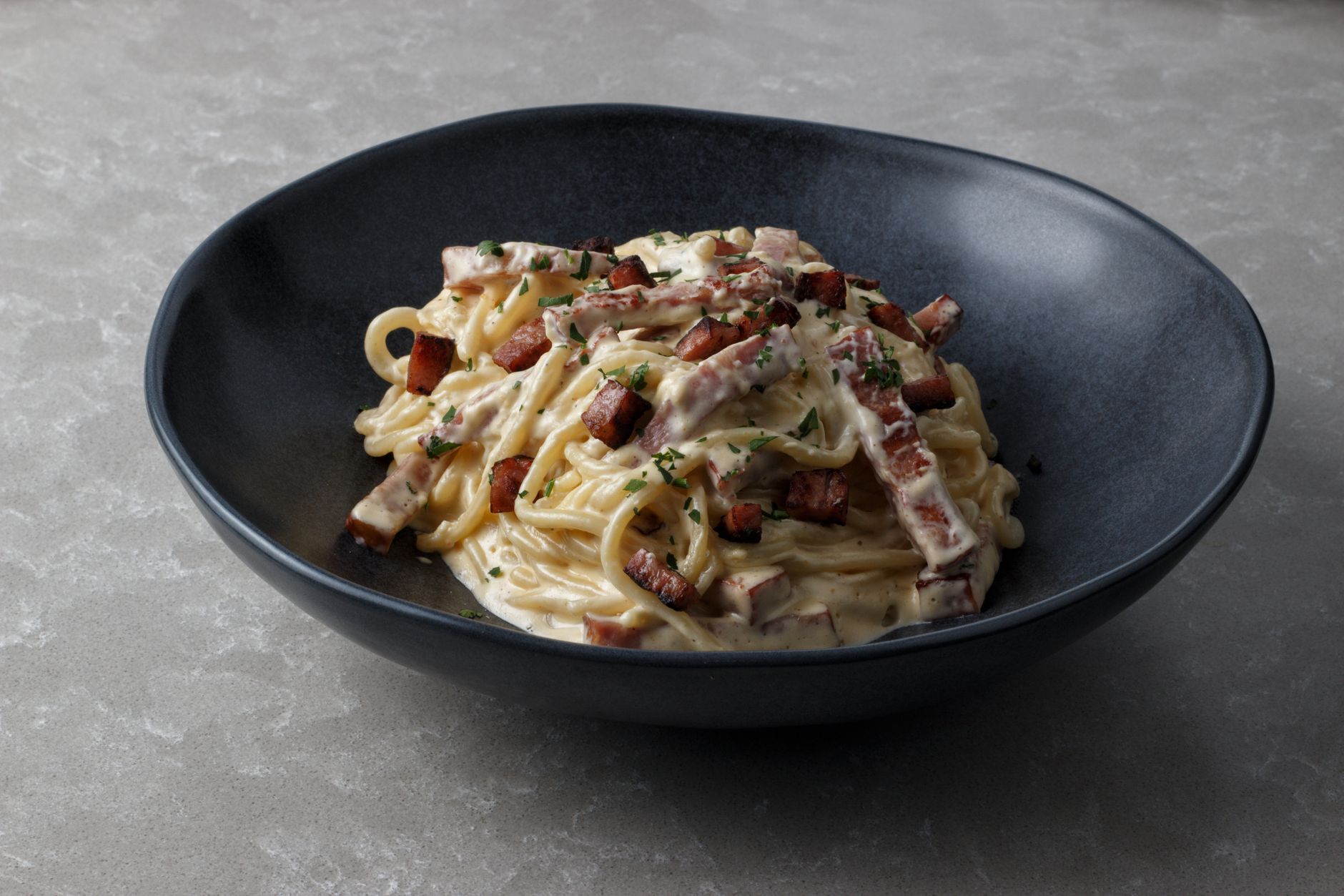 Piatto di spaghetti alla carbonara con guanciale e pepe nero