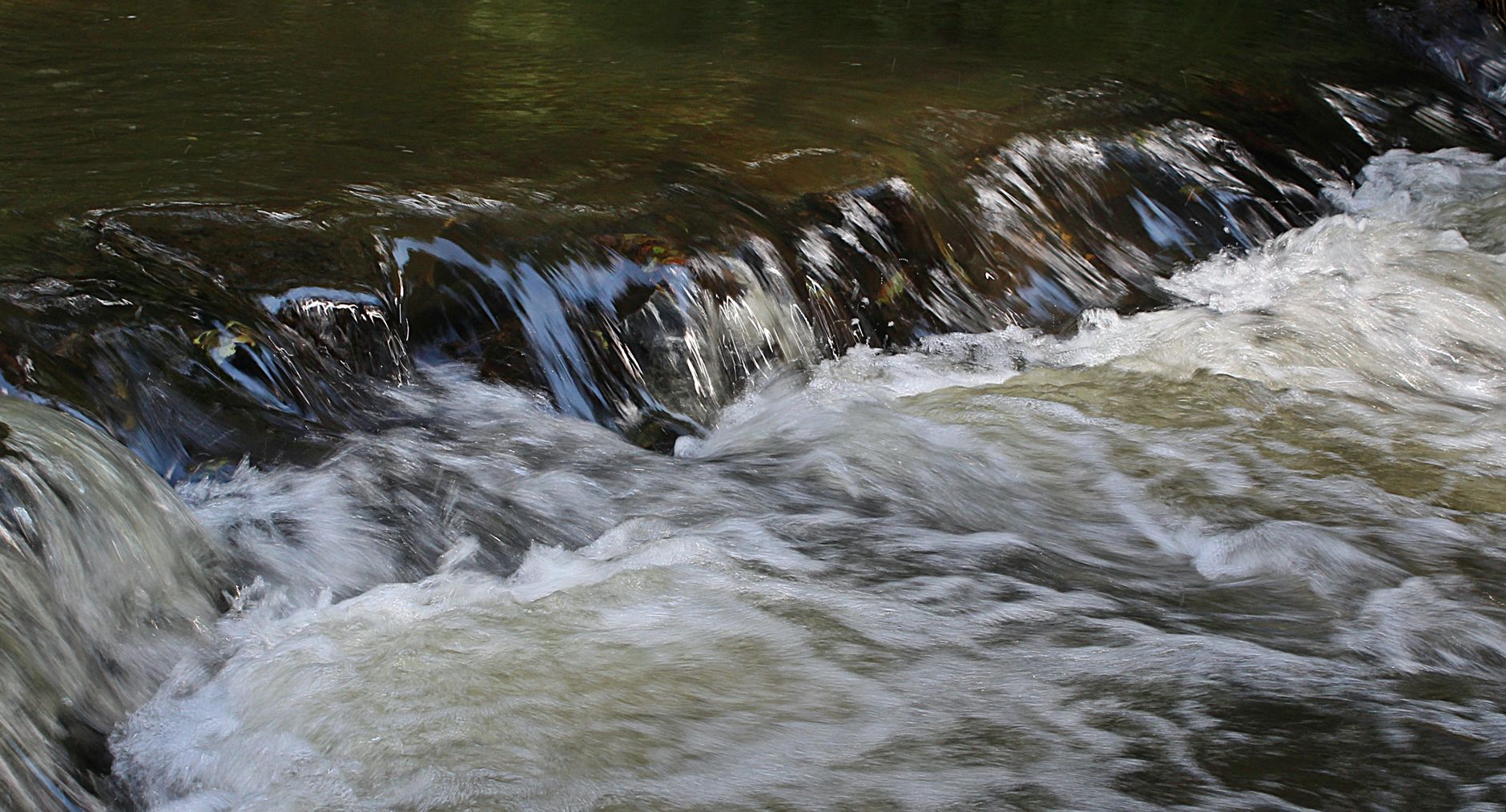 Fiume che scorre veloce tra le rocce in un bosco