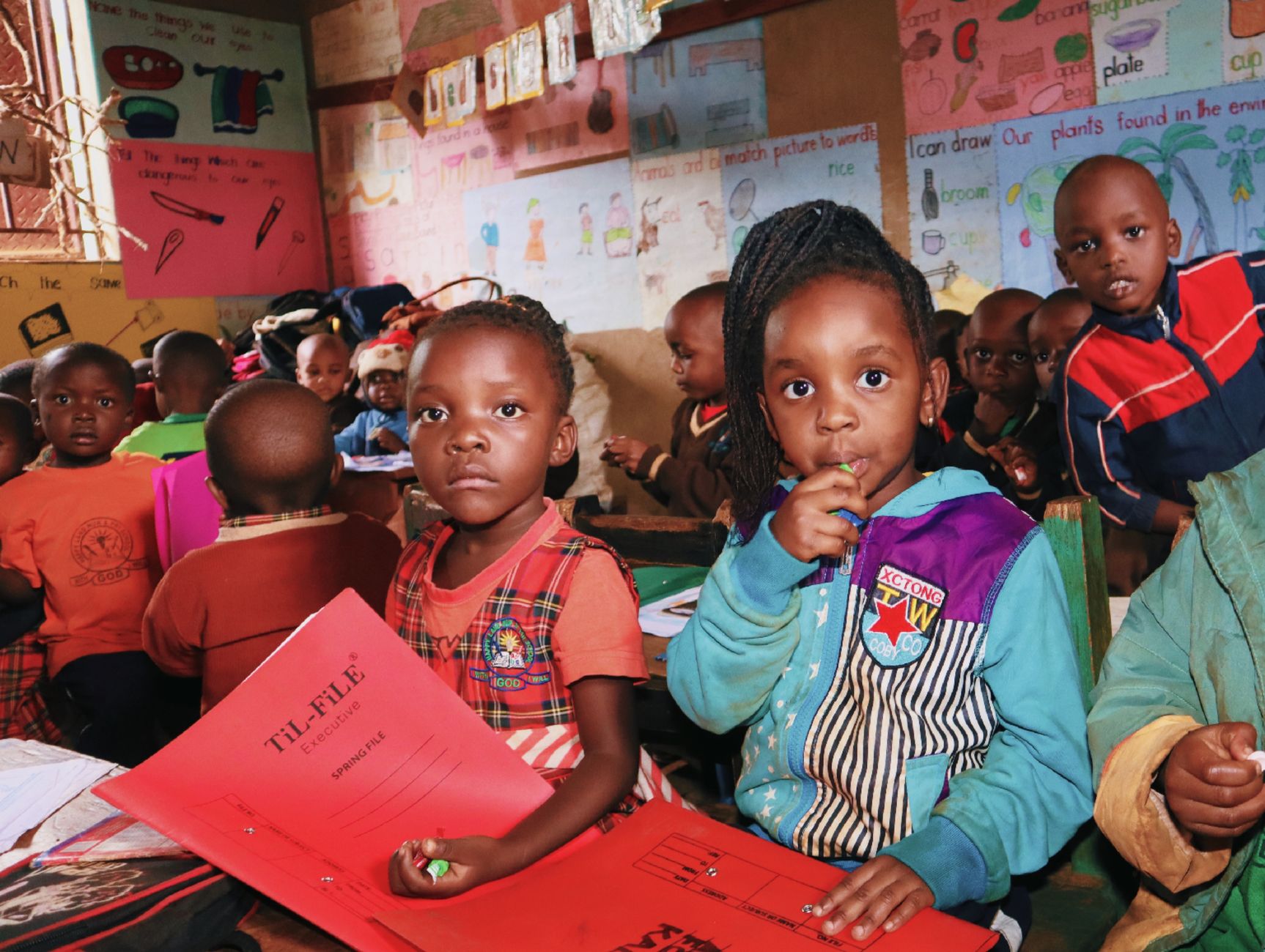 Bambini africani sorridenti davanti a una scuola