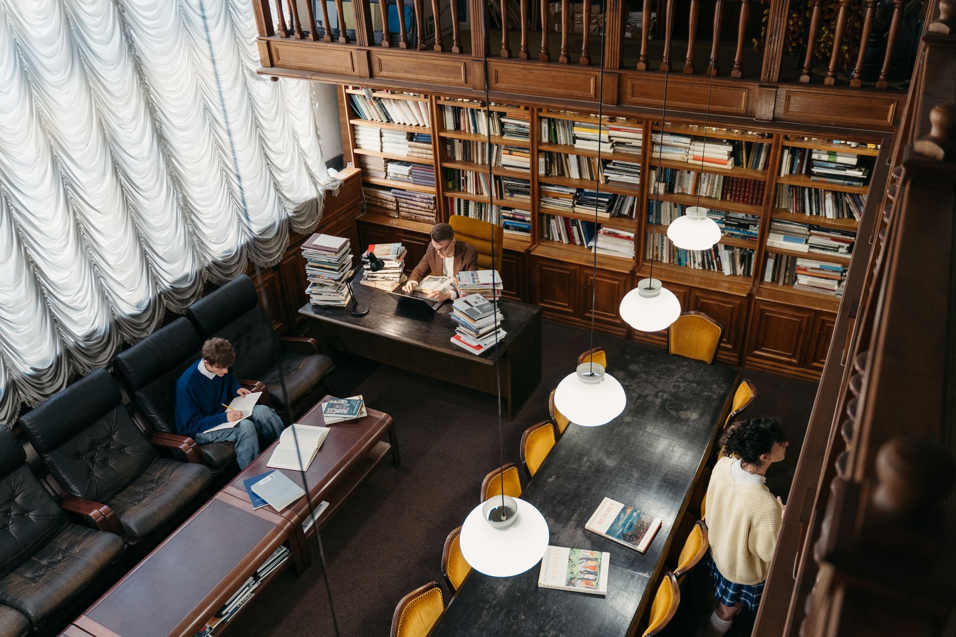 Biblioteca storica con scaffali pieni di volumi