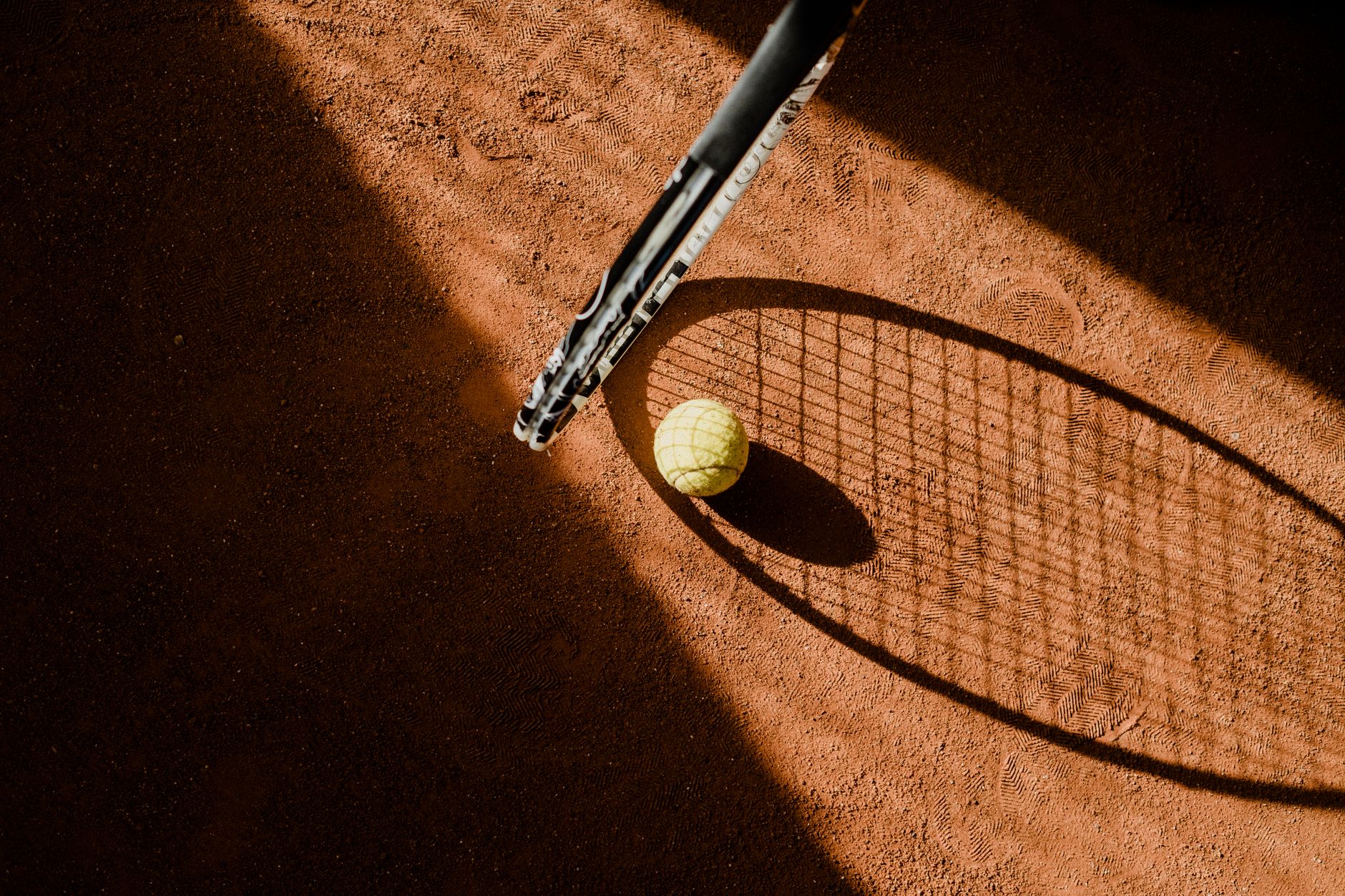 Racchetta e palline da tennis sulla terra rossa