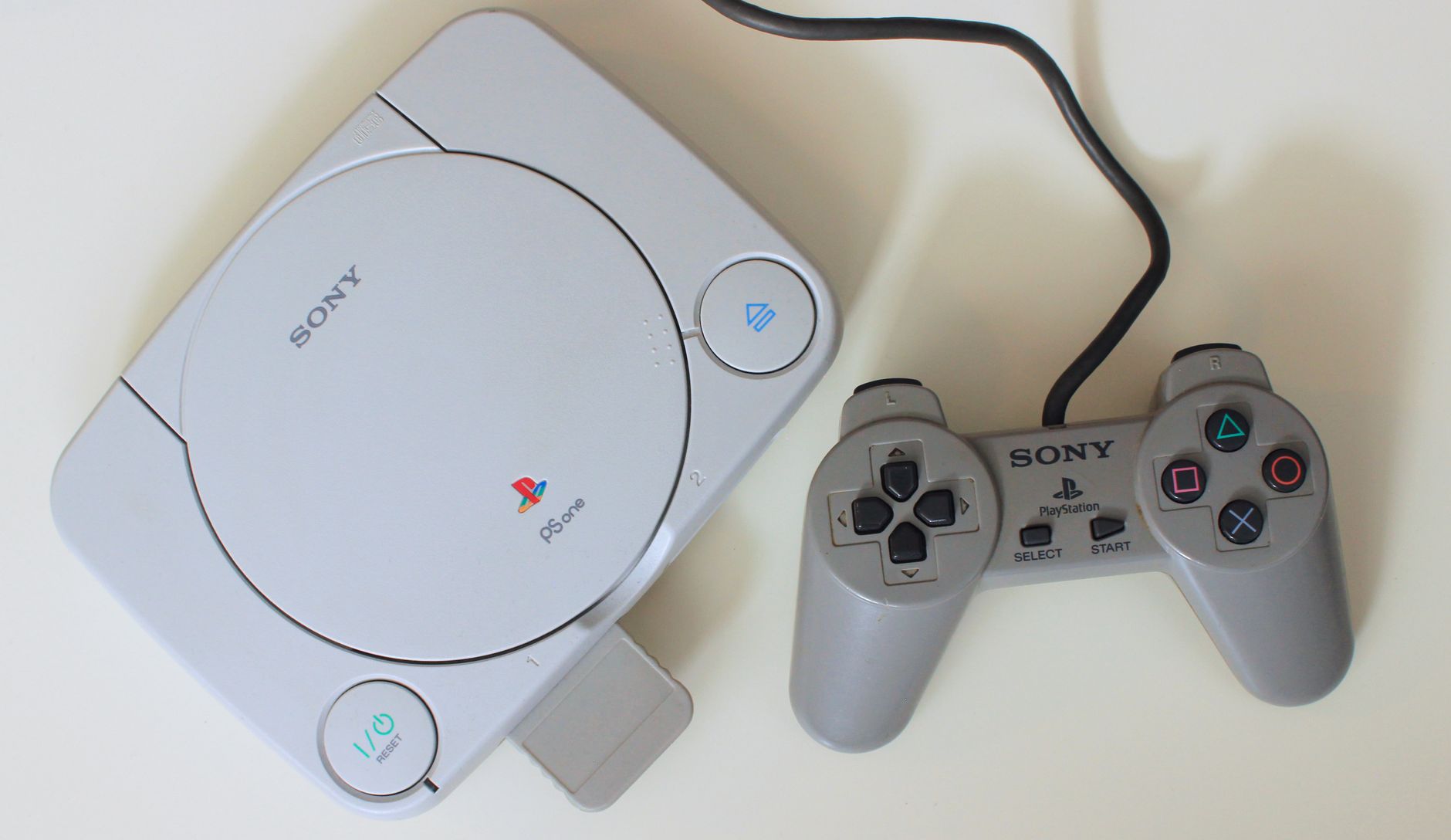 Vecchia console per videogiochi su sfondo colorato