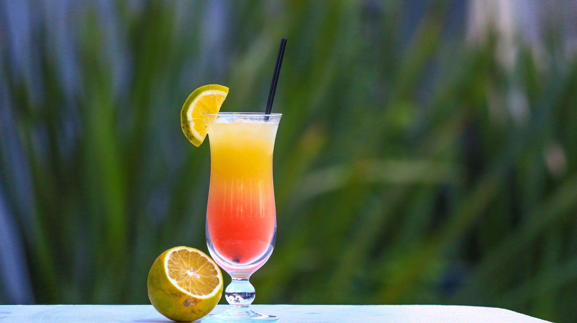 Cocktail rosso con ghiaccio e fetta d'arancia