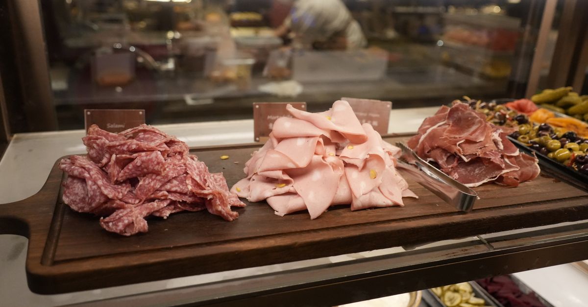 Fette sottili di mortadella rosata su un tagliere