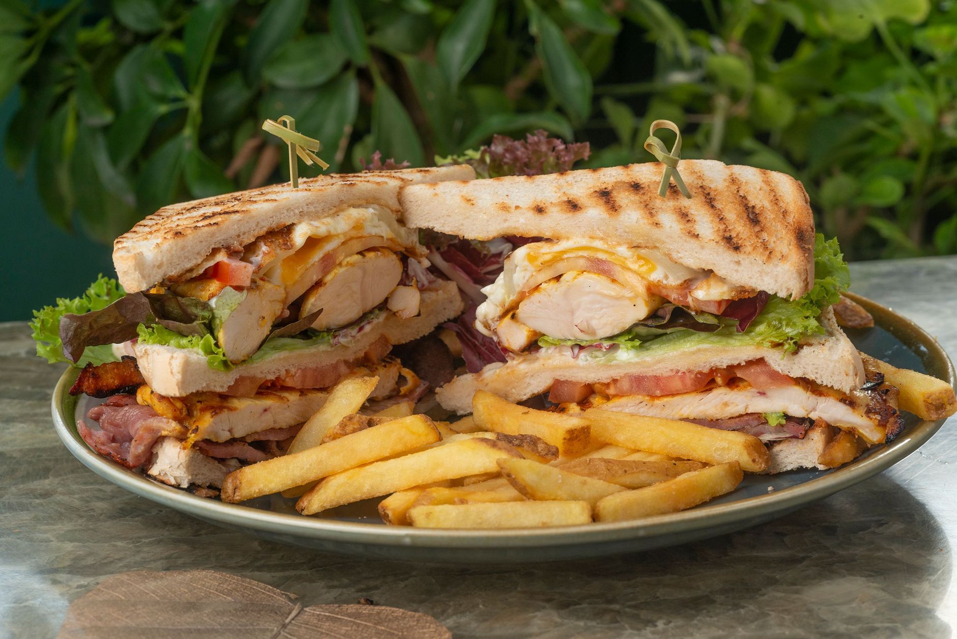 Club sandwich farcito tagliato a metà su un tagliere