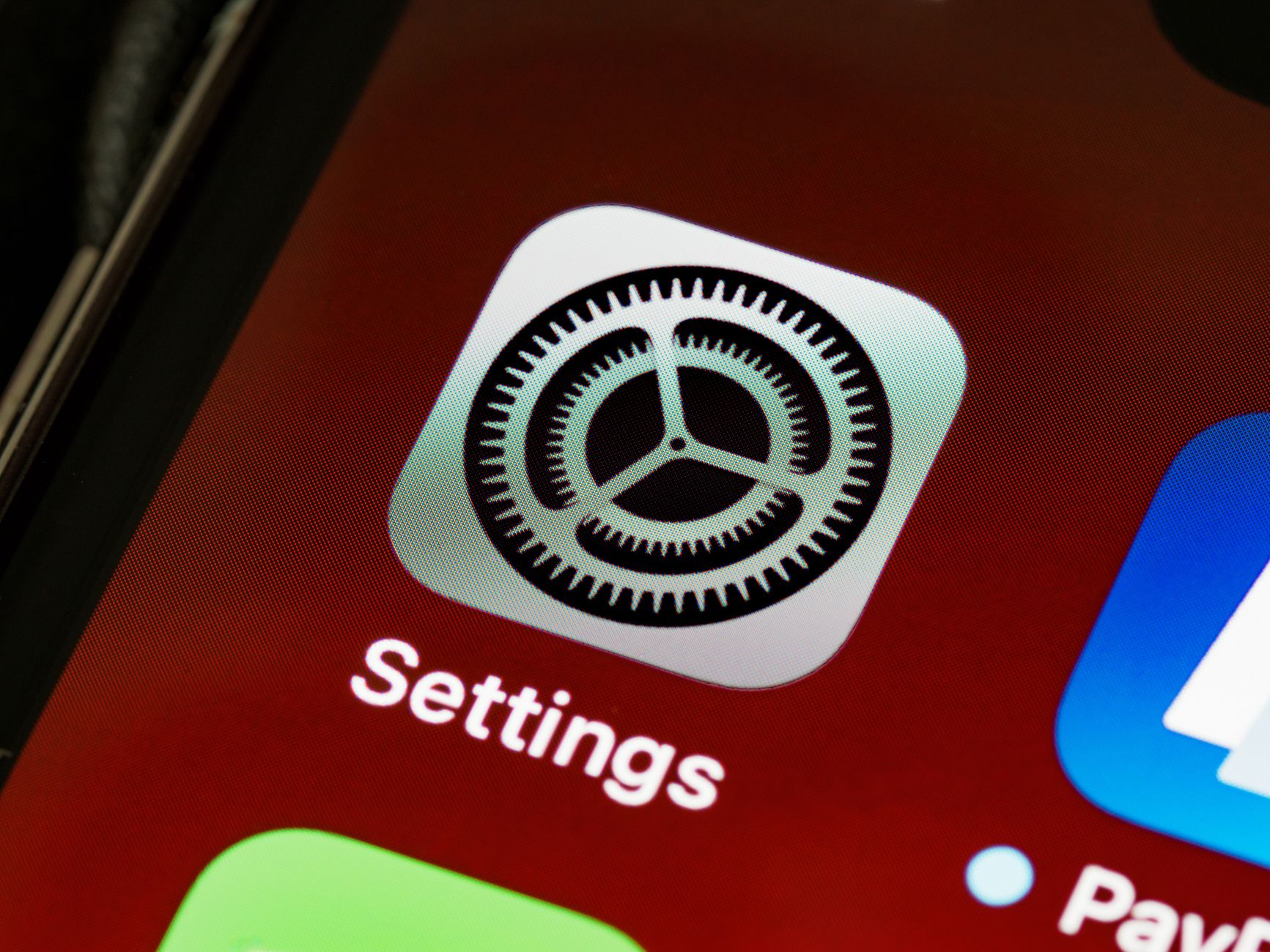 Mano che tiene uno smartphone con diverse icone di app