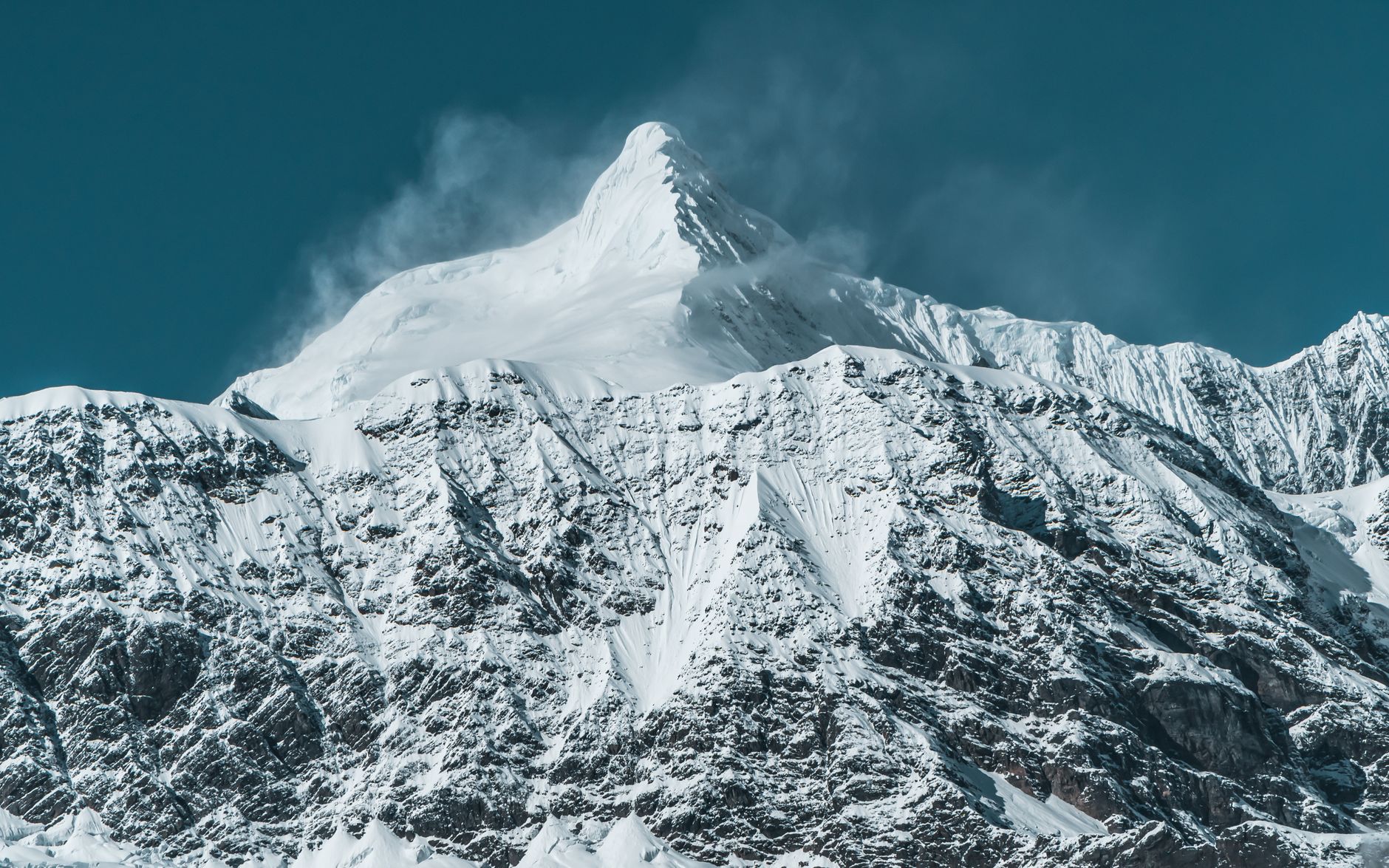Cima innevata di alta montagna tra le nuvole