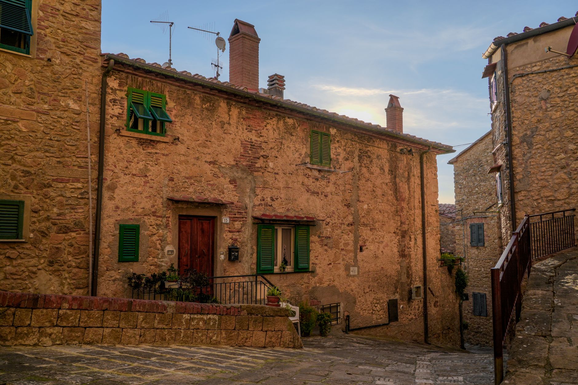 Stradina di un borgo con case in pietra e fiori