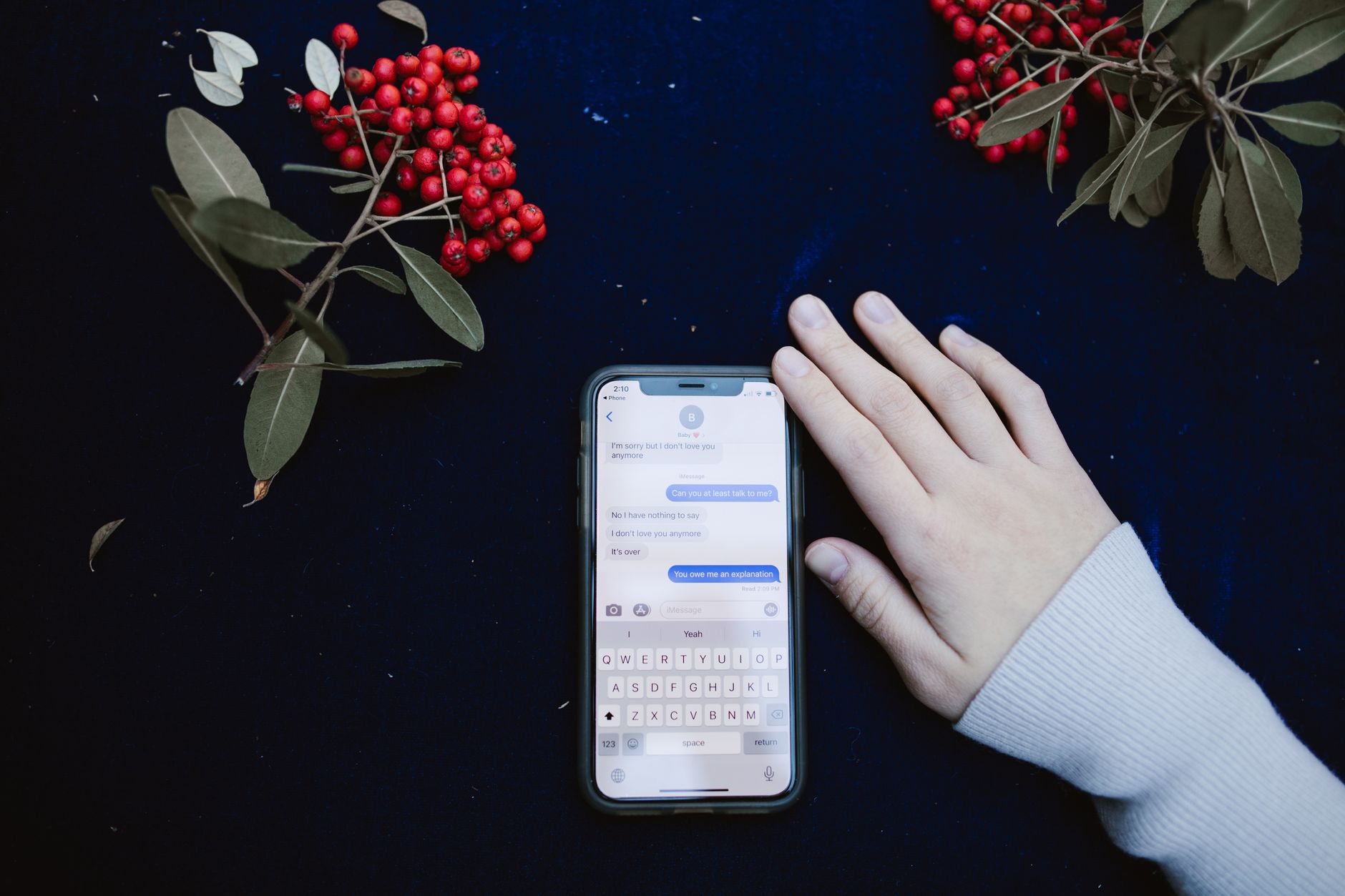 Persona che digita un messaggio con emoji sul telefono