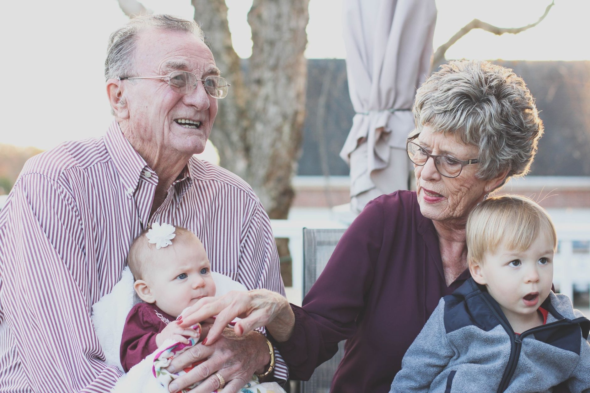 Nonni sorridenti insieme ai nipoti all'aperto