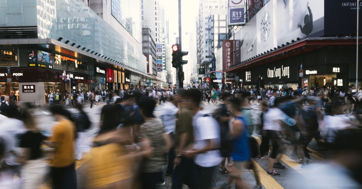 Molte persone che camminano in una strada trafficata di città