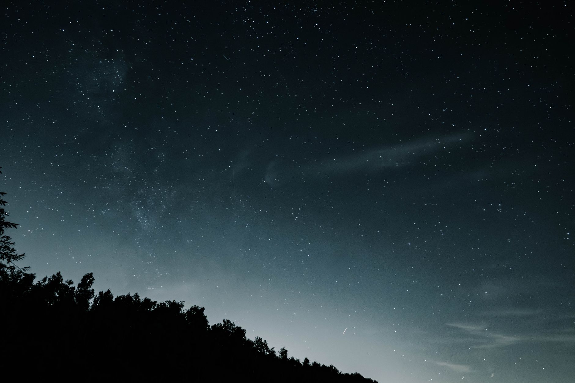 Luce misteriosa nel cielo notturno sopra un paesaggio