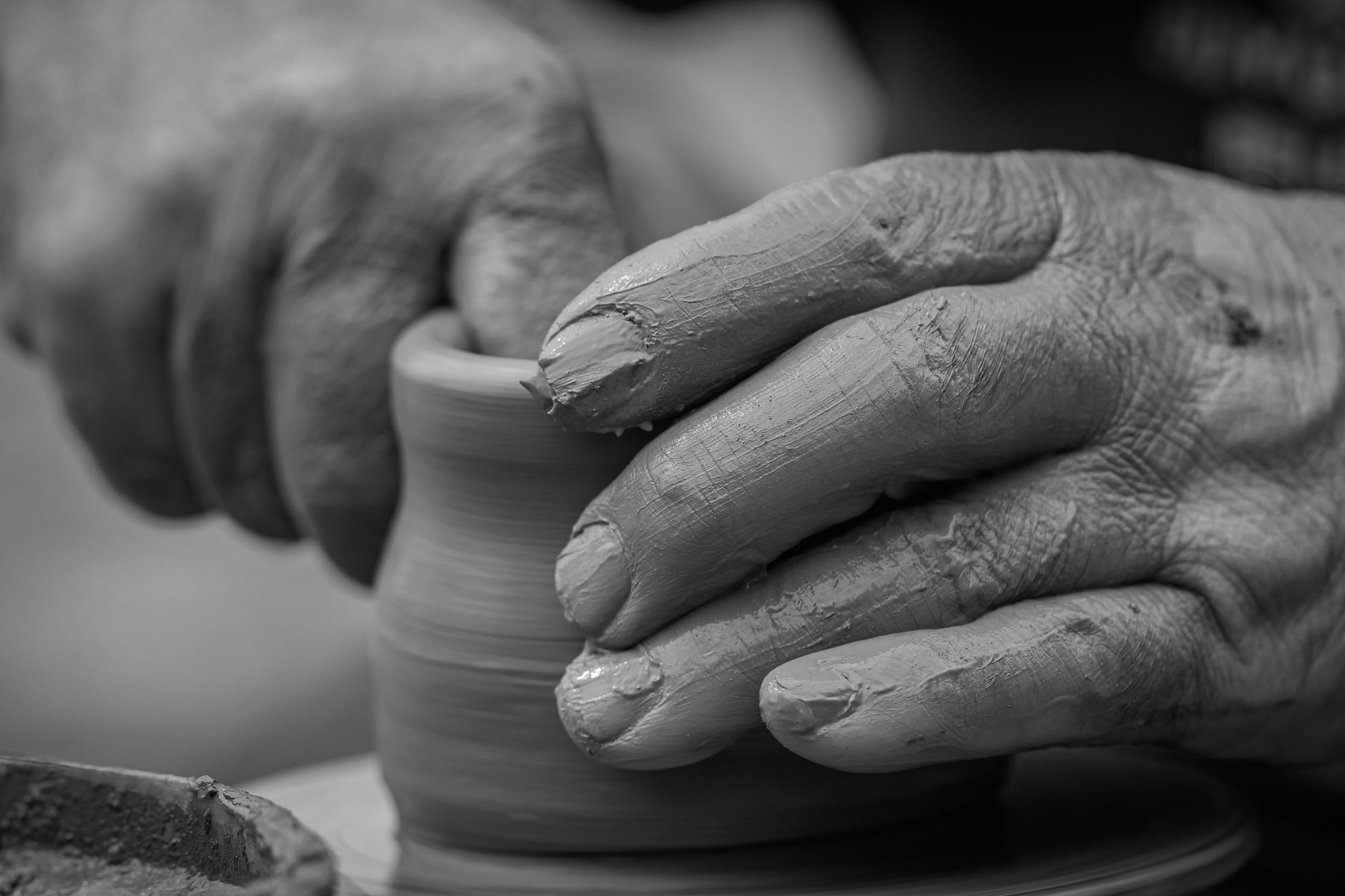 Mani che modellano un vaso di ceramica con passione