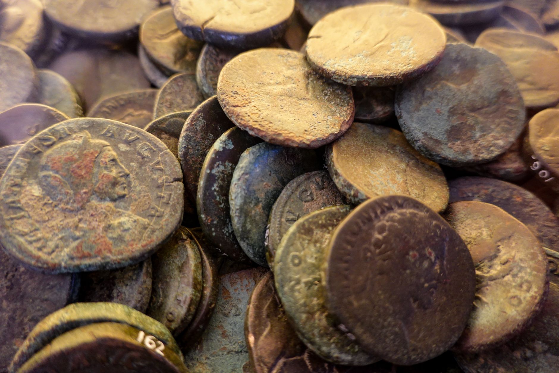 Antiche monete romane in bronzo e argento su fondo scuro