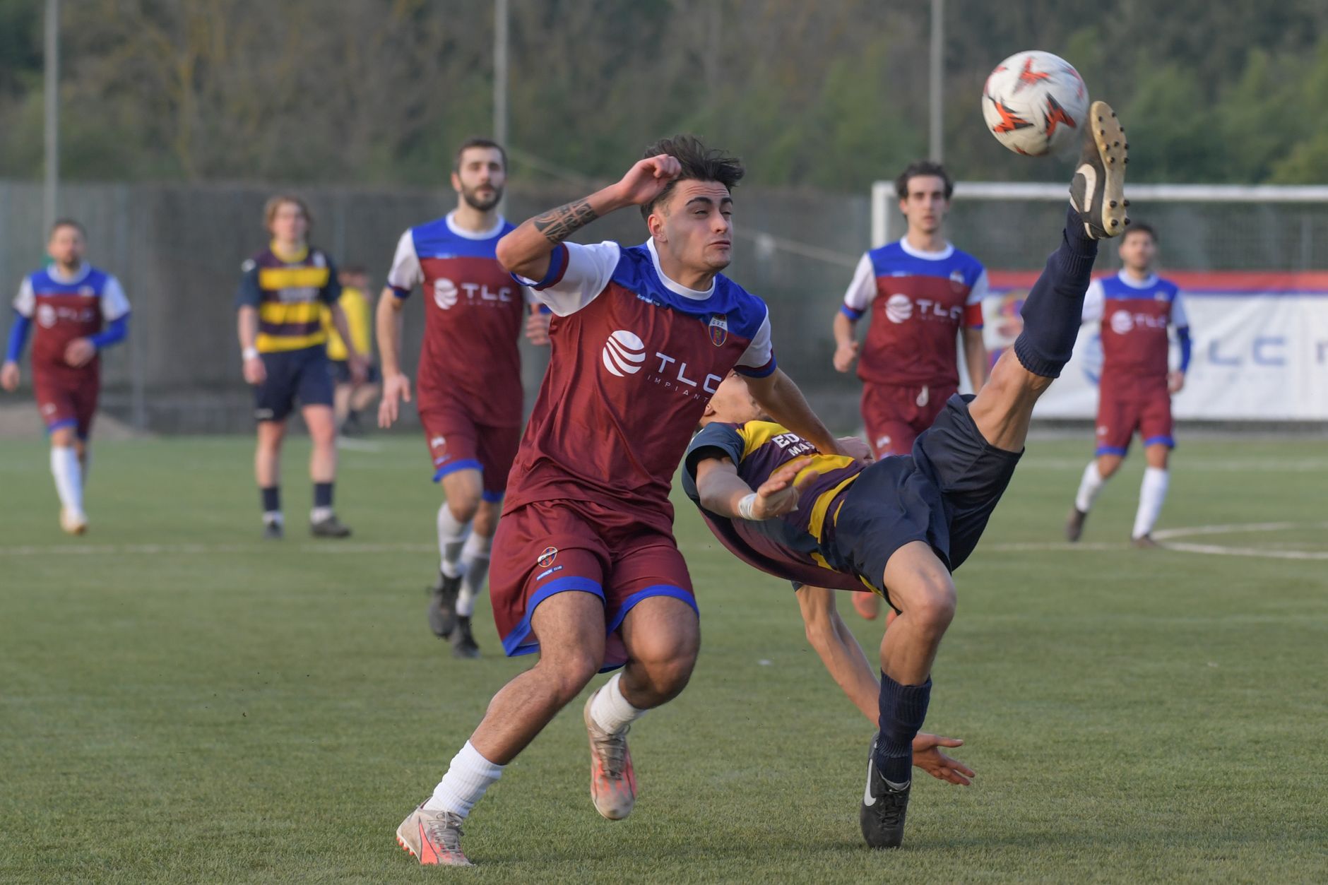 Giocatori di calcio si contendono la palla su un campo verde
