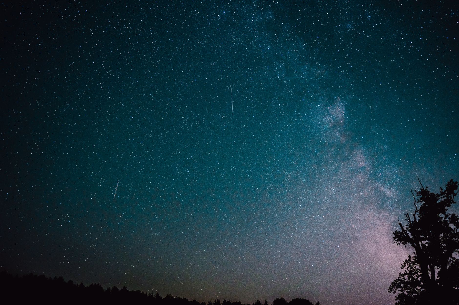 Cielo notturno stellato con scia di stella cadente durante le Perseidi