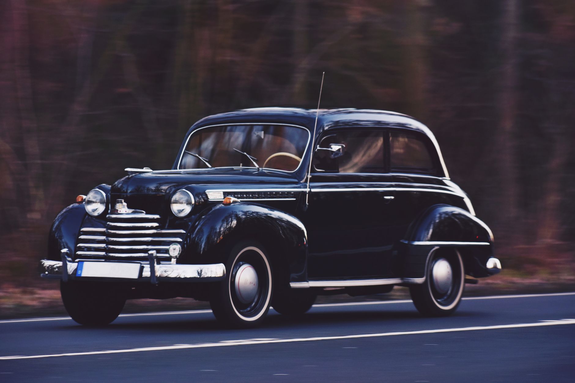 Automobile d'epoca su una strada al tramonto