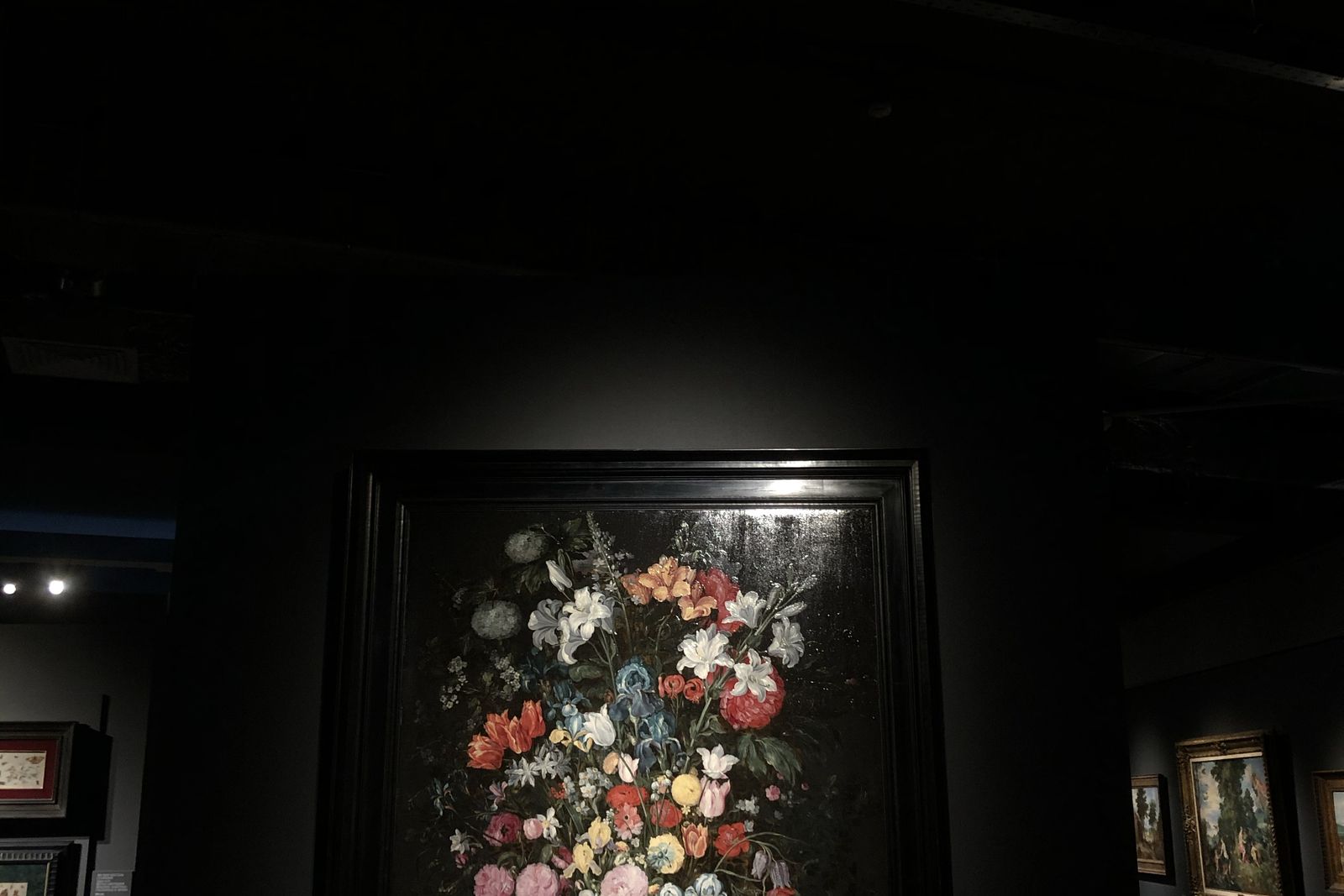 Visitatori osservano quadri in una grande sala museale