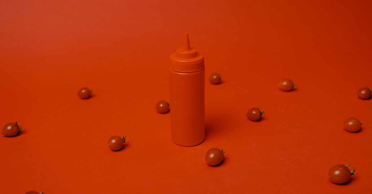 Salsa scura densa versata da una bottiglia in cucina