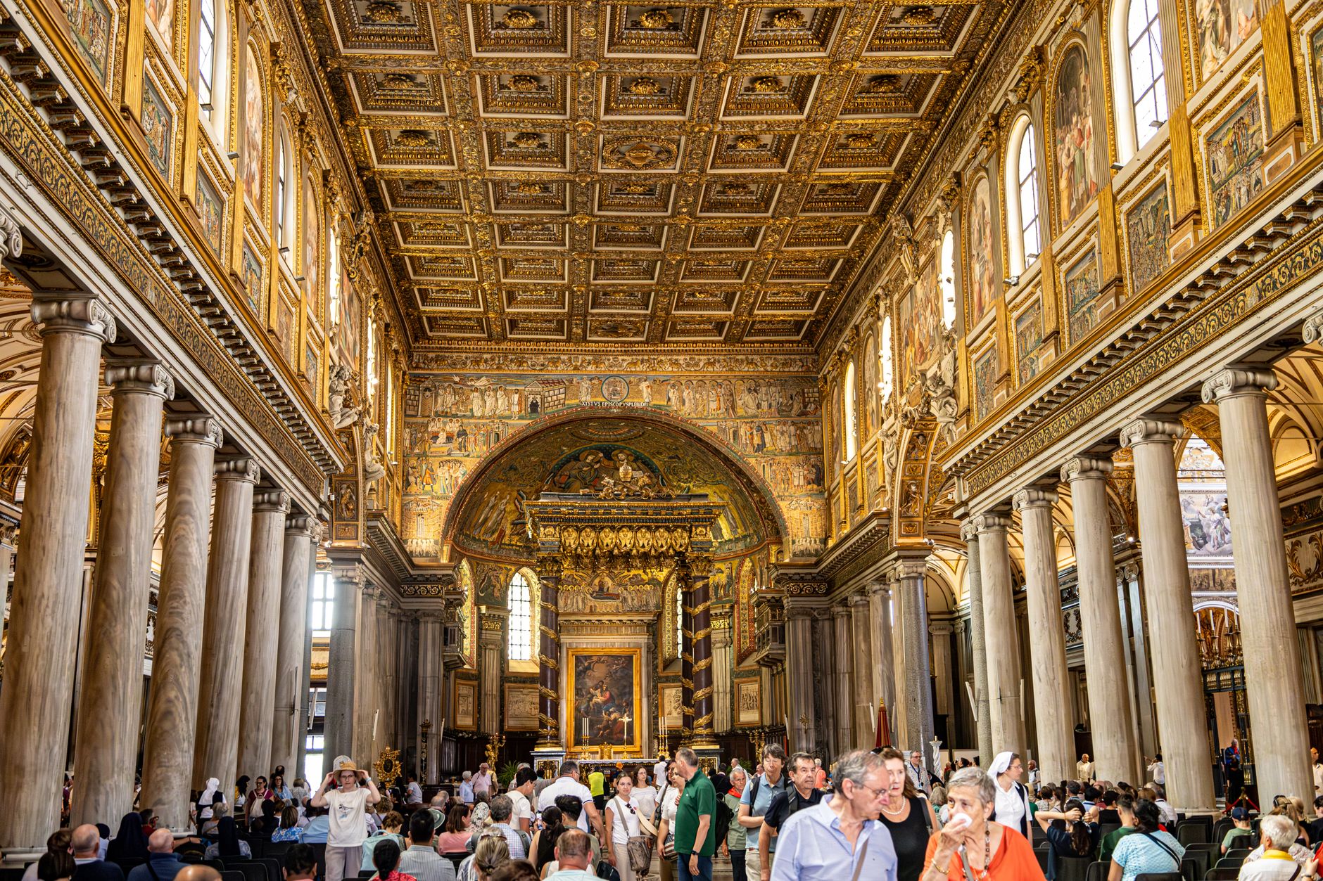 Interno di una basilica romana con colonne e affreschi