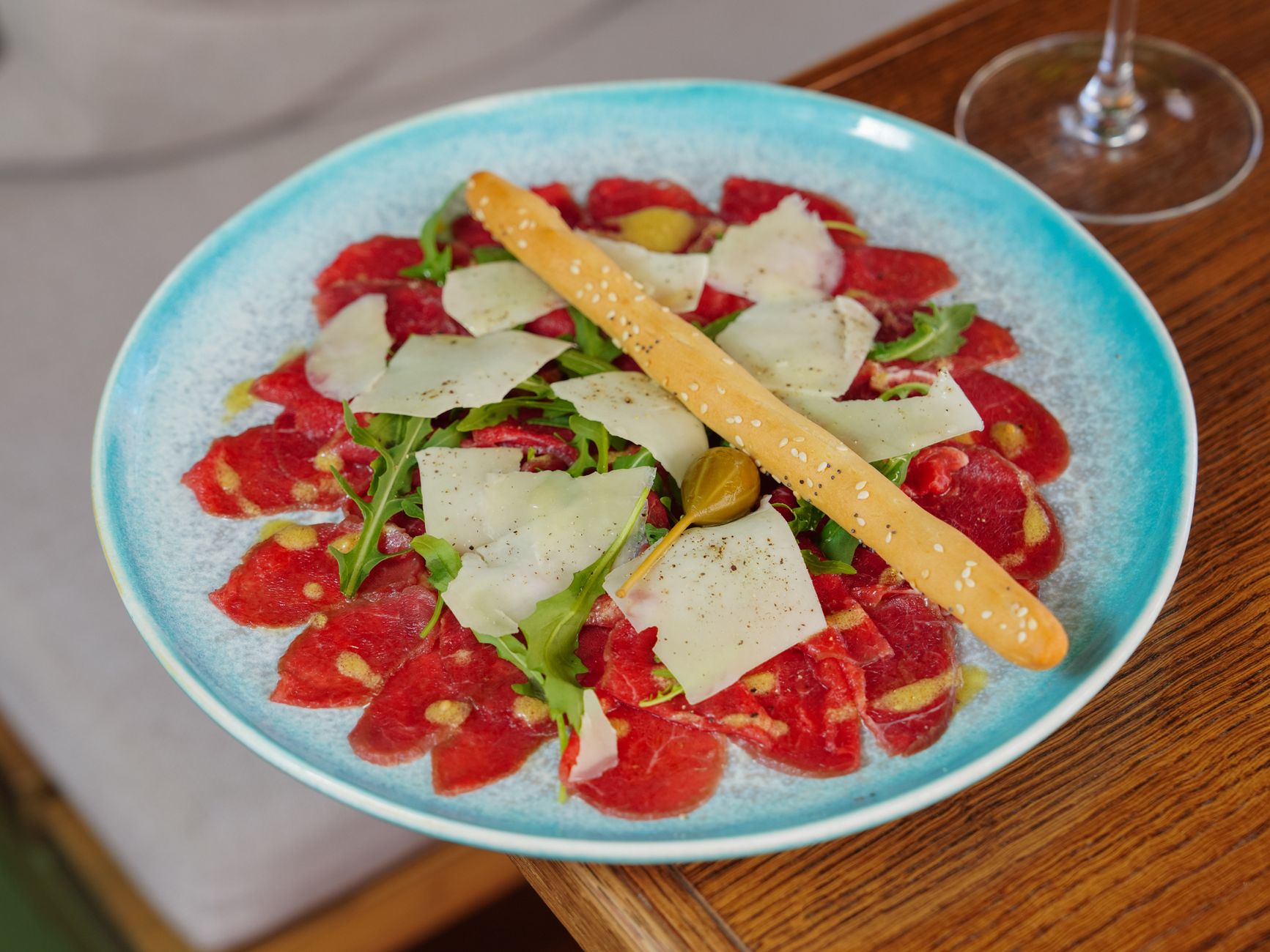 Fette sottili di carpaccio di manzo condite su un piatto bianco